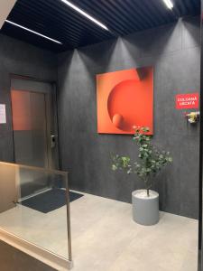 a room with a painting on the wall and a plant at DBO Kaufland-Vivo in Baia Mare