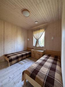 two beds in a room with a window at Brunella house at Villa Vlada in Gāršmuiža
