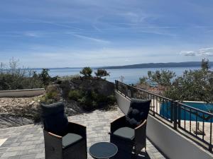 a balcony with two chairs and a view of the water at Apartman Magic View in Baška Voda