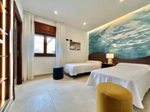 a room with two beds and a painting on the wall at Golf Sea&Pool Cactus Villa in Buenavista del Norte +40 photos