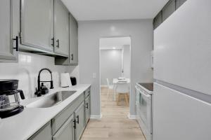 a white kitchen with a sink and a table at SMV Coastal Retreat Near Shore in Jacksonville Beach