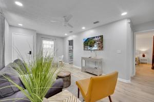 a living room with a couch and a tv on a wall at SMV Coastal Retreat Near Shore in Jacksonville Beach
