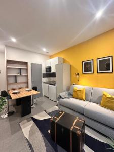 a living room with a couch and a table at Le coeur Jaune de Mulhouse in Mulhouse