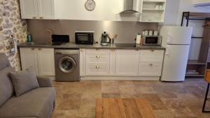 a kitchen with a refrigerator and a washing machine at Arceau de Saint Martin in Vallon-Pont-dʼArc