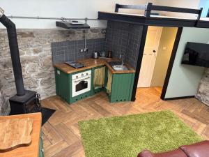 a small kitchen with a stove and a green cabinet at Wonrek in Penzance +11 photos