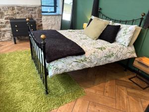a bedroom with a bed with a green wall at Wonrek in Penzance