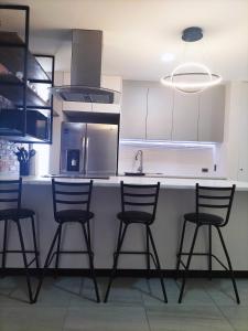 a kitchen with four chairs and a counter with a sink at Loft SB in Aguascalientes