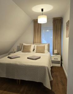 a bedroom with a large white bed with a window at Dom Nad Jeziorem z Jacuzzi in Mrągowo +23 photos