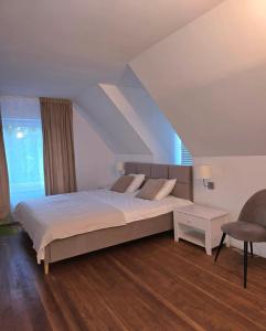a bedroom with a large bed and a chair at Dom Nad Jeziorem z Jacuzzi in Mrągowo