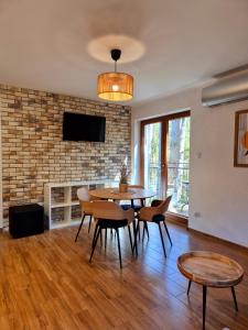 a living room with a table and chairs and a tv at Apartamenty na Spacerowej in Dębki