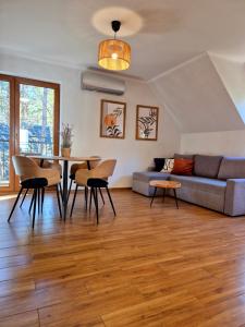 a living room with a couch and a table and chairs at Apartamenty na Spacerowej in Dębki