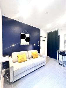 a living room with a white couch with yellow pillows at L horizon bleu in Mulhouse