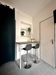 a table and two stools in a room at L horizon bleu in Mulhouse