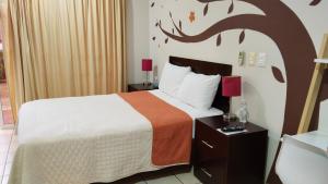 een slaapkamer met een bed met een muurschildering van bomen aan de muur bij Terraza Studios in Cabo San Lucas