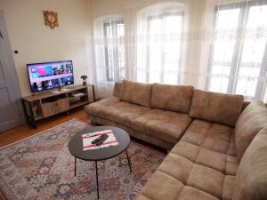 a living room with a couch and a tv at Fisi Heritage Home in Shkodër
