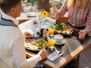 a group of people sitting at a table eating food at Radisson Blu Ridzene Hotel, Riga in Riga