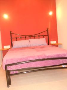 1 dormitorio con 1 cama con pared roja en Number 12, en Birgu