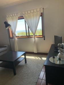 un salon avec une table et une fenêtre dans l'établissement Carminho beach house, à Vila do Conde