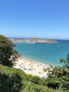 a beach with a bunch of people in the water at Wonrek in Penzance