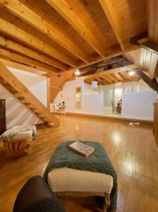 a large room with a bed in a room with wooden ceilings at Les gites Romeline in Montviron