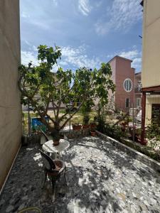 a patio with a tree and a table and a chair at Da Iro in Larisa