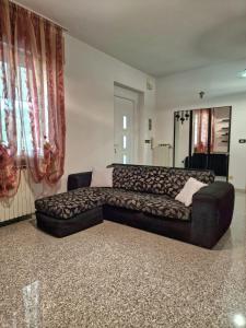 a black couch in a living room with red curtains at HolidHome - Casa di Francesco in San Giovanni Ilarione +11 photos