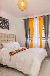 Un dormitorio con una cama grande con cortinas naranjas. en Asili Haven - 2 bedroom, en Nanyuki