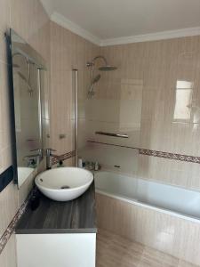een badkamer met een wastafel en een bad en een wastafel bij Luanco para vivir y disfrutarlo VUT7223AS in Luanco