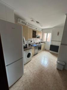een keuken met een witte koelkast en een vaatwasser bij Luanco para vivir y disfrutarlo VUT7223AS in Luanco