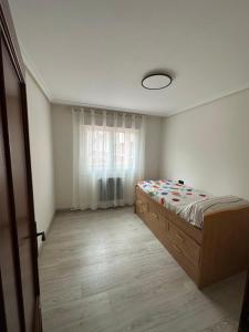 een slaapkamer met een bed en een raam bij Luanco para vivir y disfrutarlo VUT7223AS in Luanco