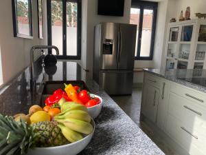 a bowl of fruits and vegetables on a kitchen counter at La Maison du Parc 47 in Fumel