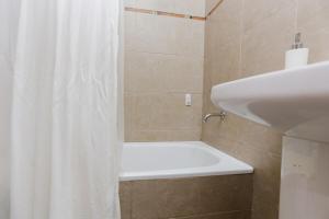 a bathroom with a shower curtain and a sink at Candioti I Apartment - Santa Fe in Santa Fe +17 photos