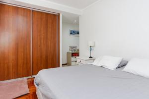a bedroom with a white bed and a wooden cabinet at Candioti I Apartment - Santa Fe in Santa Fe