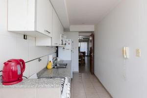 a kitchen with white cabinets and a red appliance on the counter at Candioti I Apartment - Santa Fe in Santa Fe