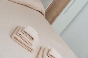 a close up of a white bed with two white towels at Casa Donatella, in riva al mare! in Cala Liberotto