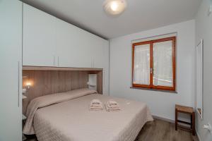 a bedroom with a bed with two towels on it at Casa Donatella, in riva al mare! in Cala Liberotto