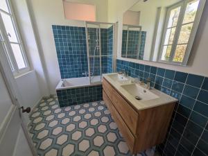 Pontenx-les-ForgesにあるGrande demeure familialeの青いタイル張りのバスルーム(シンク、鏡付) +10枚の写真