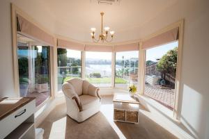 a living room with a chair and a large window at Spacious Lake Front Home- Private Beach in Encounter Bay