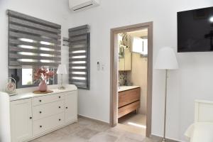 a bedroom with white cabinets and a mirror at Faros Anaplioti in Kalymnos