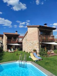 a villa with a swimming pool in front of a house at La Galiana loft nature in Casarejos