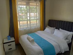 a bedroom with a bed with a large window at L&N AirBnB in Bondo