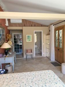 a living room with a table and a chair at Chambre de charme climatisée, avec piscine in Grasse