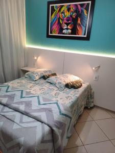 a bedroom with a bed with a painting on the wall at Apartamento a 2 Minutos da Praça! in Domingos Martins +1 photo
