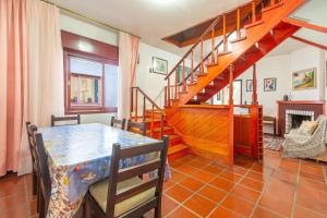 a dining room with a table and a staircase at Casa 5 Quartos no Centro para 14 Pessoas in Gramado