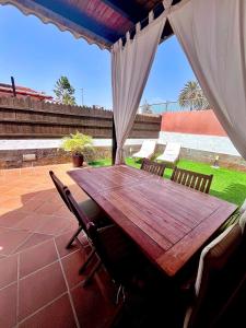 a wooden table and chairs on a patio at CAN HOST YUMBO - Private Terrace AA in San Bartolomé de Tirajana