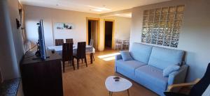 a living room with a blue couch and a table at Vista marina VUT-7215-AS in Bañugues