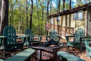 a group of chairs and a fire pit in front of a cabin at 2-bedroom cabin, with a Fireplace, PS5, BBQ, fitness room, and a private hot tub in Hedgesville