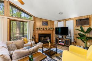 a living room with a couch and a tv at 2-bedroom cabin, with a Fireplace, PS5, BBQ, fitness room, and a private hot tub in Hedgesville