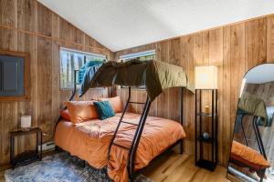 a bedroom with a bed in a room with wooden walls at 2-bedroom cabin, with a Fireplace, PS5, BBQ, fitness room, and a private hot tub in Hedgesville +23 photos