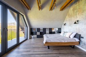 a bedroom with a bed and large windows at Kaszubskie Dzikie Kąty in Piechowice +18 photos